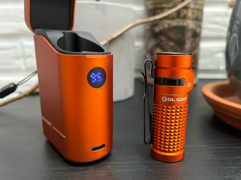 La Olight Baton 4 à côté de son boitier sur une table