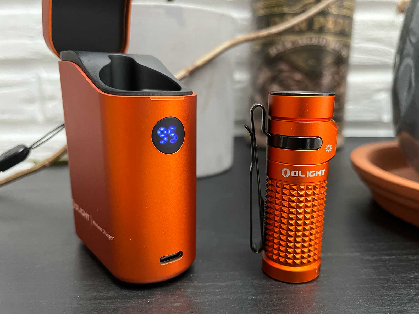 La Olight Baton 4 à côté de son boitier sur une table