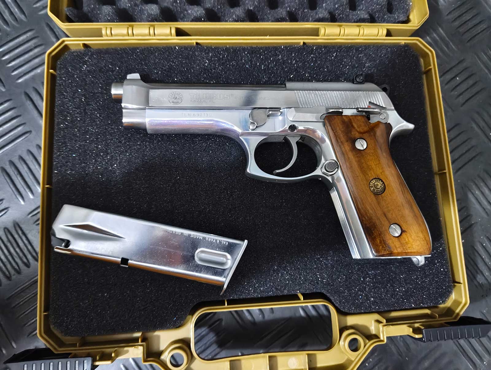 Un pistolet Taurus 99 AFS et son chargeur dans sa mallette
