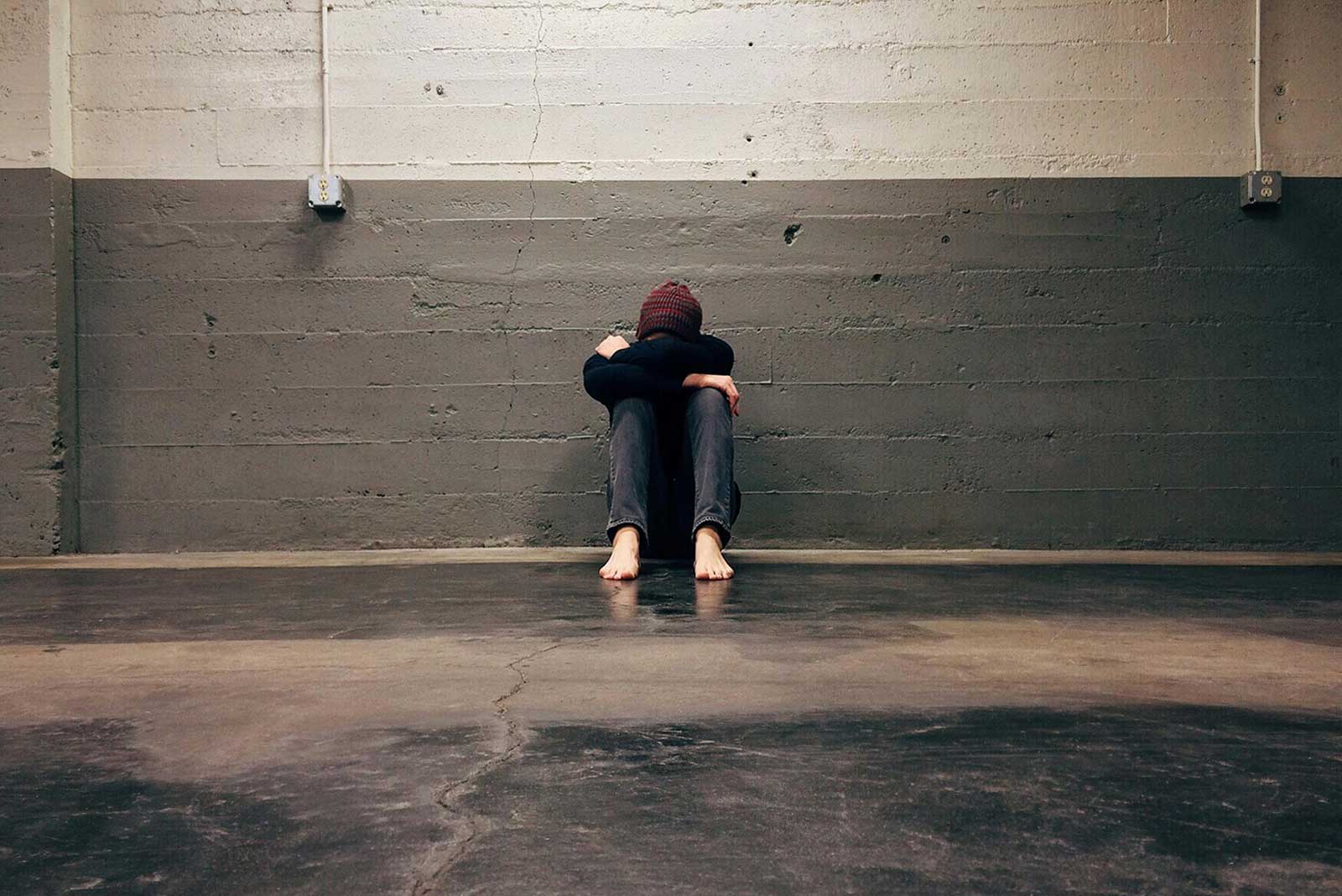 Une personne souffrant d'hoplophobie assise contre un mur