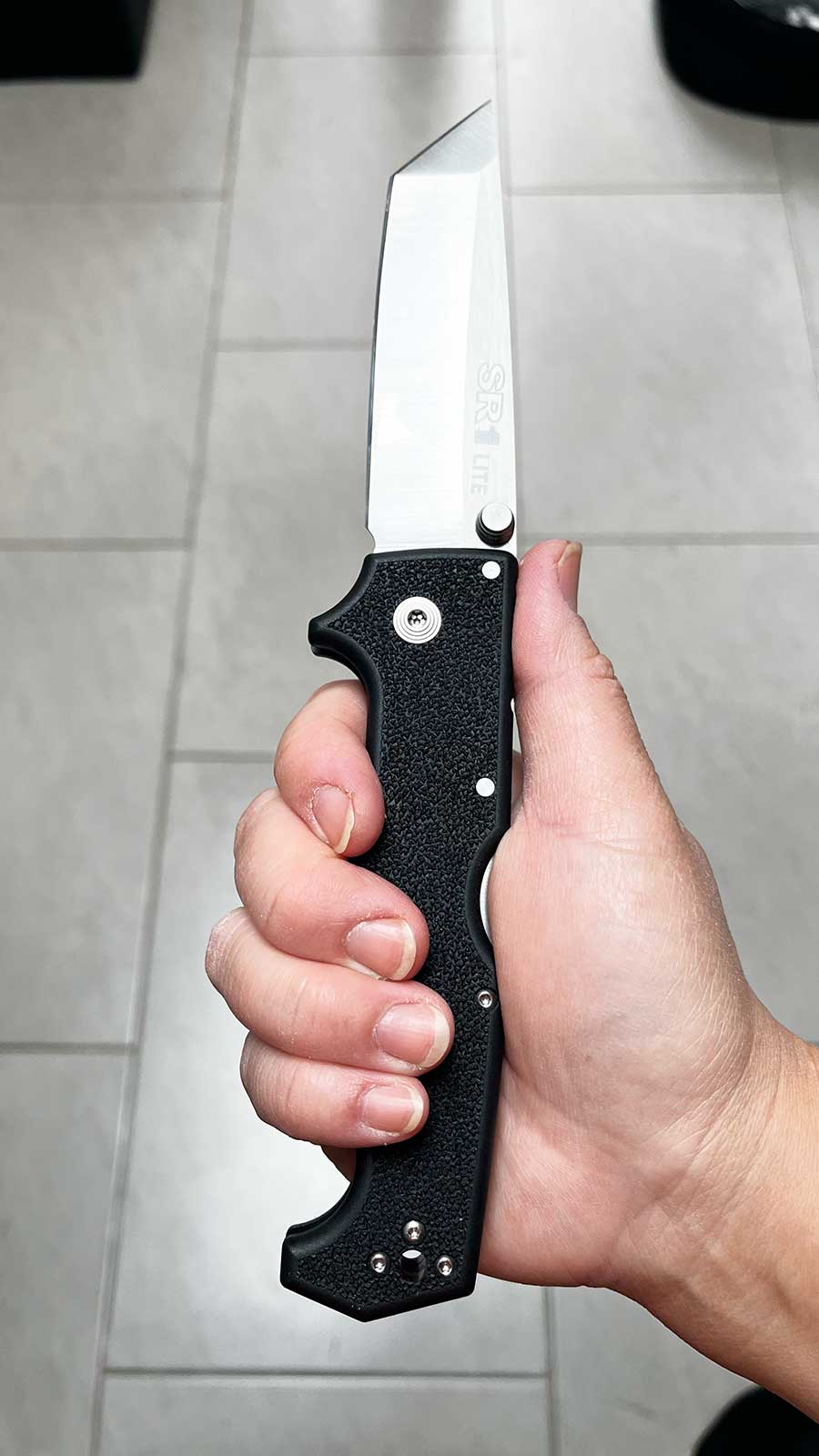 Le Cold Steel SR1 Lite ouvert dans la main d'un utilisateur