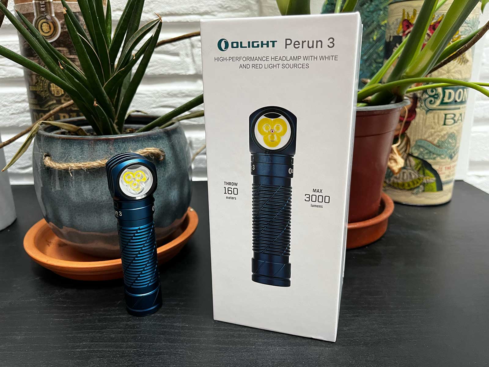 La Lampe Olight Perun 3 posée à côté de son packaging