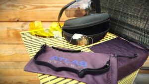 lunettes-balistiques-atlas-defense-stend-up sur fond boisé avec accessoires